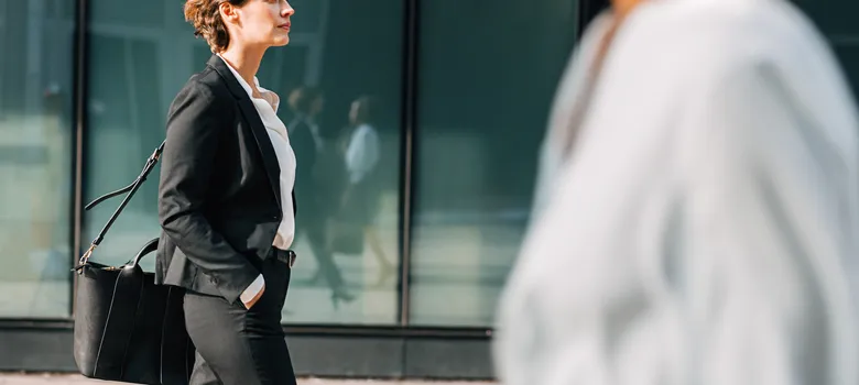 Side view businesswoman walking footpath city.