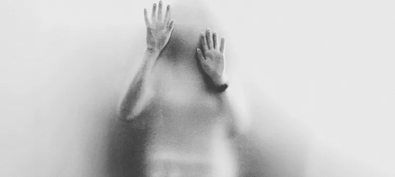 Person seen through condensed glass window
