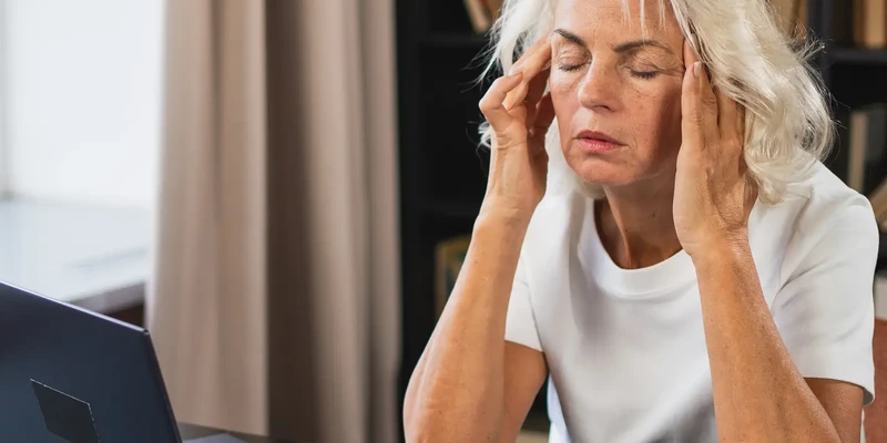 liberty mental health woman sitting desk head hands