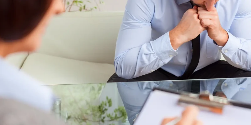 liberty therapy man blue shirt tie sitting table woman