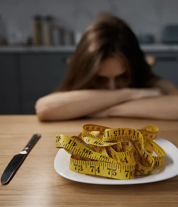 depressed-anorexic-woman-looking-plate-with-measuring-tape-served-dinner