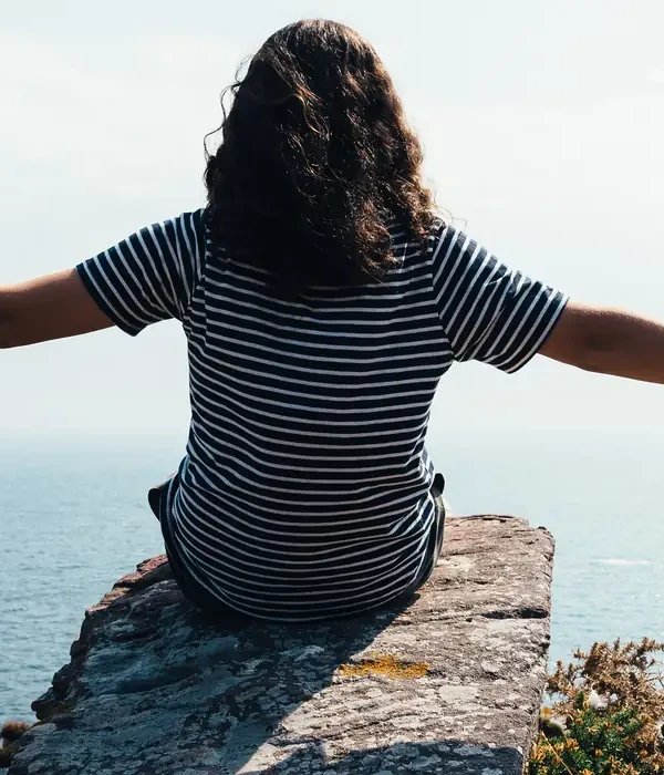 liberty-environment-woman-sitting-rock-overlooking-ocean-enviroment-page