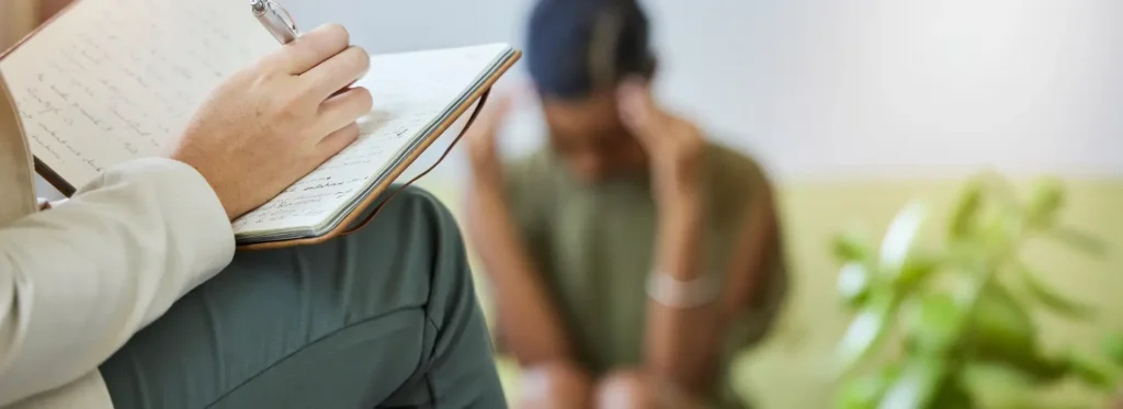Therapist writing about poisoning symptoms in a distressed patient.