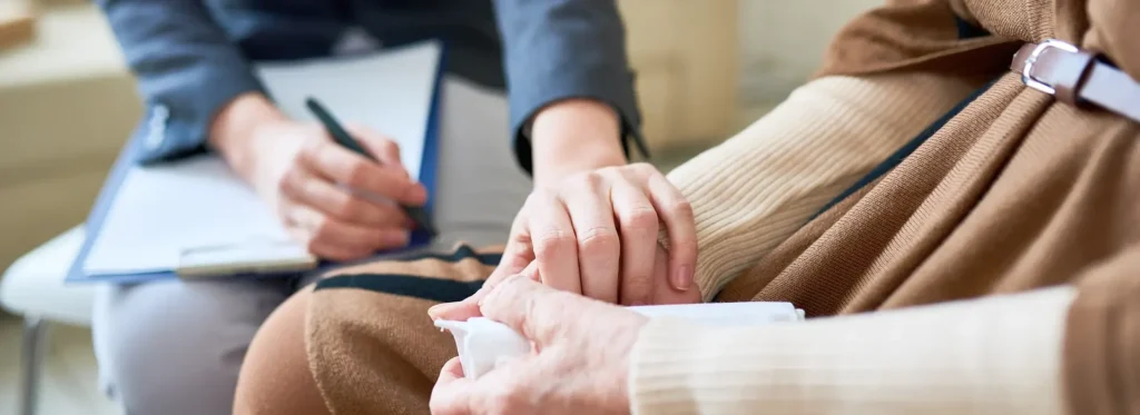 Therapist holding her patient's hand.